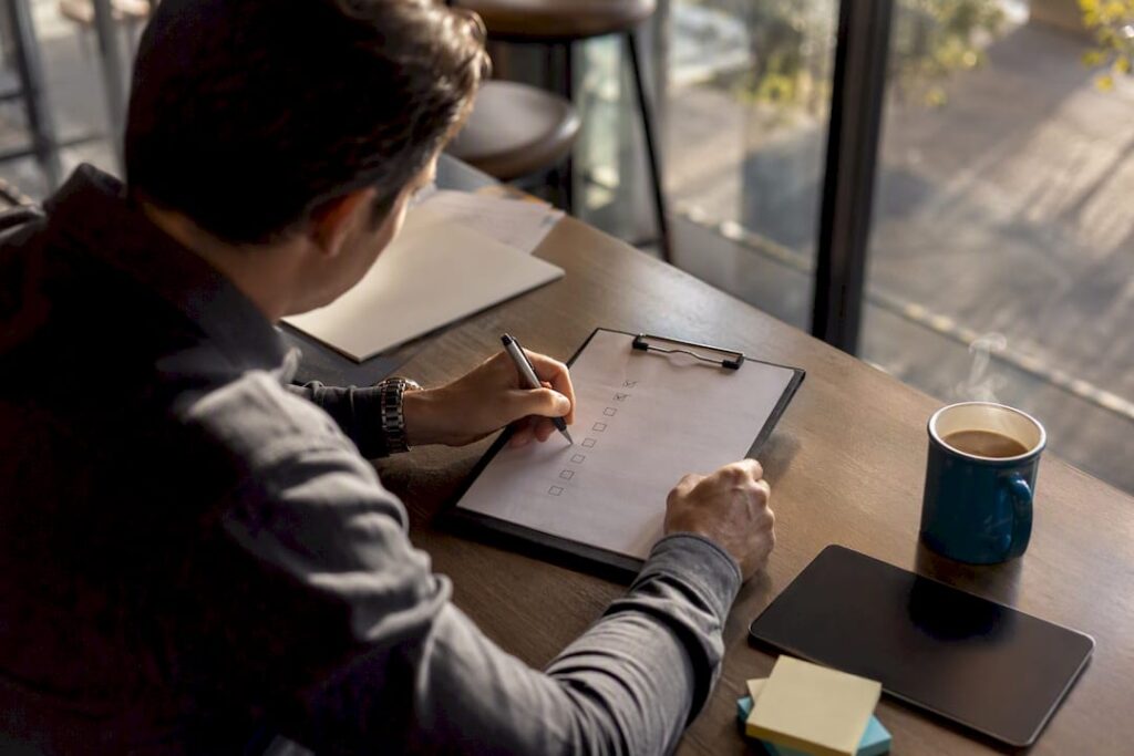 Recruiter filling sales hiring scorecard on clipboard