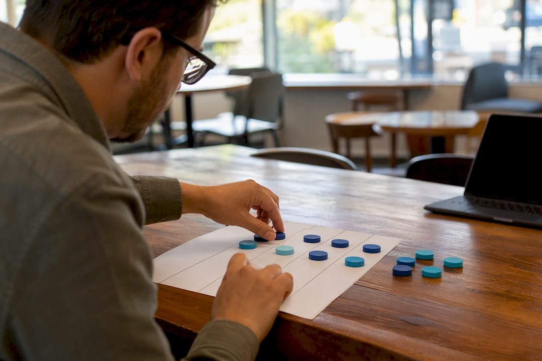 Hands adjusting weighted tokens on scoring sheet